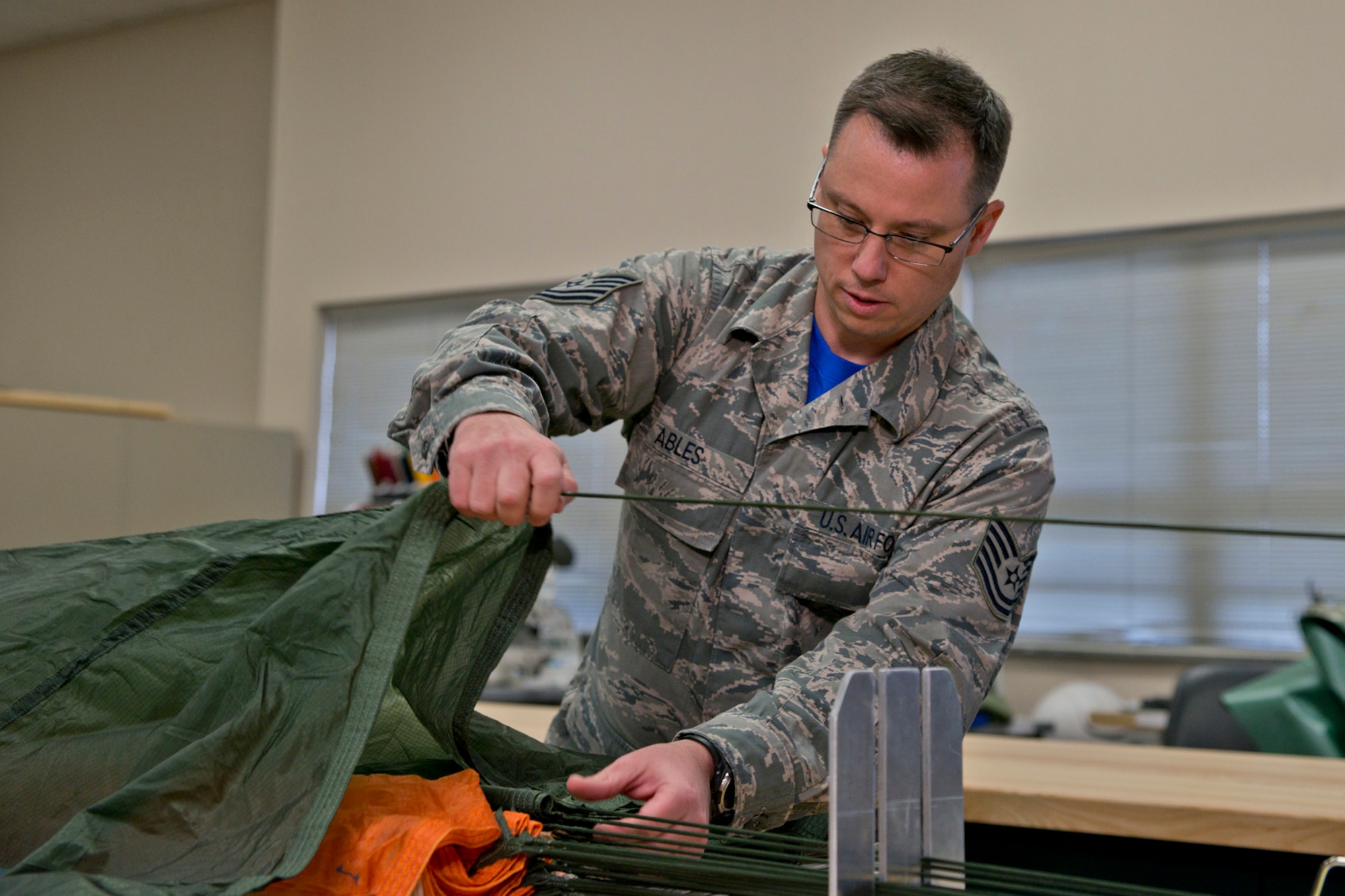 U.S. Air Force Tech. Sgt. Jeremy Ables, aircrew flight equipment, 913th Operations Support Squadron, demonstrates proper procedures involved in packing a parachute for an advertising video crew at Little Rock Air Force Base, Ark., Oct. 4, 2015. Ables was one of many subject matter experts photographed and interviewed for future use by the Air Force Reserve Command in promotional and recruiting advertising. (U.S. Air Force photo by Master Sgt. Jeff Walston/Released)