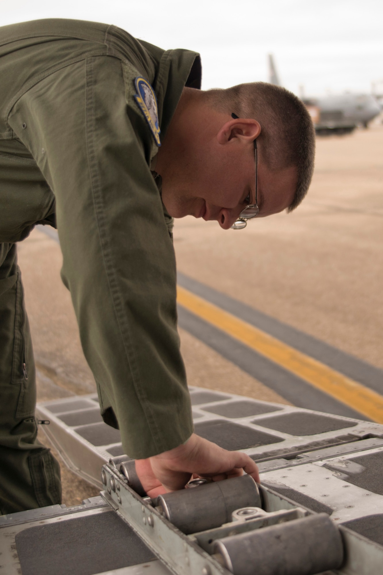 U.S. Air Force Tech. Sgt. Dereck Johnson, a loadmaster assigned to the 327th Airlift Squadron, installs roller conveyors to assist 96th Aerial Port Squadron personnel with loading operations at Little Rock Air Force Base, Ark., Oct. 4, 2015. Johnson installed the rollers to load pallets after 96 APS personnel finished loading and unloading a Humvee during Operation MOBEX 2015, which was an aerial port deployment training exercise. (U.S. Air Force photo by Master Sgt. Jeff Walston/Released)