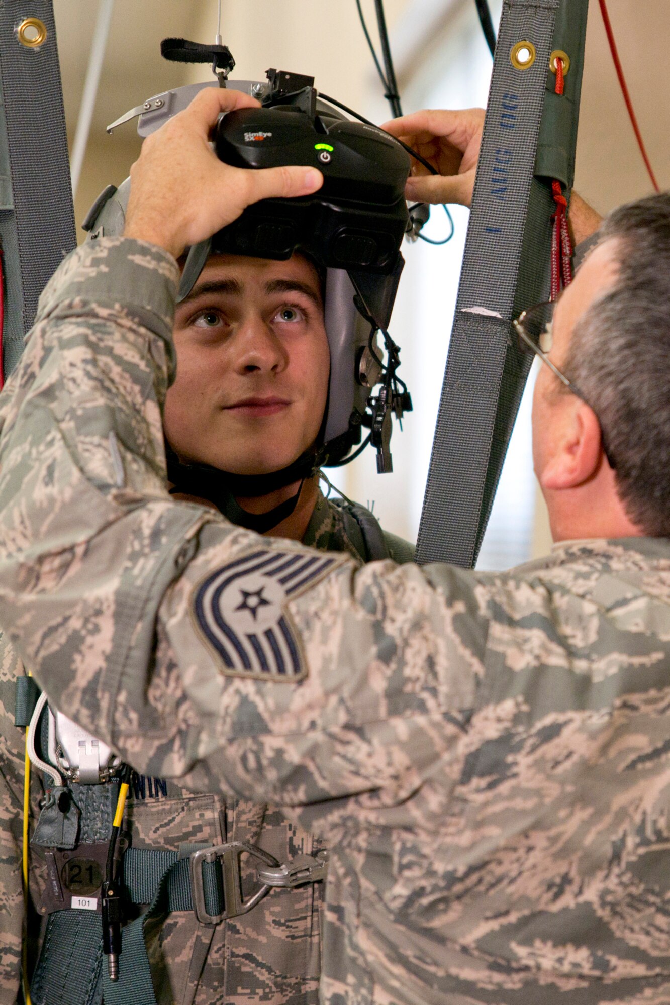 U.S. Air Force Tech. Sgt. Bryan Wilson, aircrew equipment flight chief, 913th Operations Support Squadron, places virtual reality glasses on Senior Airman Casey Godwin, aircrew flight equipment apprentice, 913 OSS, at Little Rock Air Force Base, Ark., Oct. 4, 2015. The simulator allows Airmen to learn from a virtual jump from an aircraft, experiencing freefall, parachute openings and landings as well as many different malfunction scenarios in a safe environment. (U.S. Air Force photo by Master Sgt. Jeff Walston/Released)