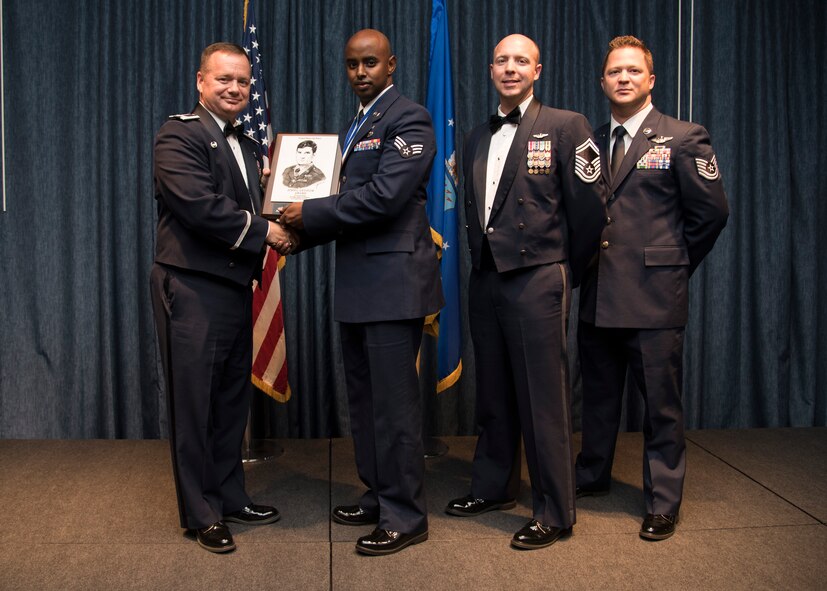 Senior Airman Mahad Hagimohamed from the 446th Aeromedical Staging Squadron, receives the John L. Levitow Award during the Airman Leadership School graduation Oct. 15, 2015, at Fairchild Air Force Base, Wash. The Levitow Award is presented to the student who demonstrated the most outstanding leadership and scholastic qualities. (U.S. Air Force photo/Airman 1st Class Sean Campbell)