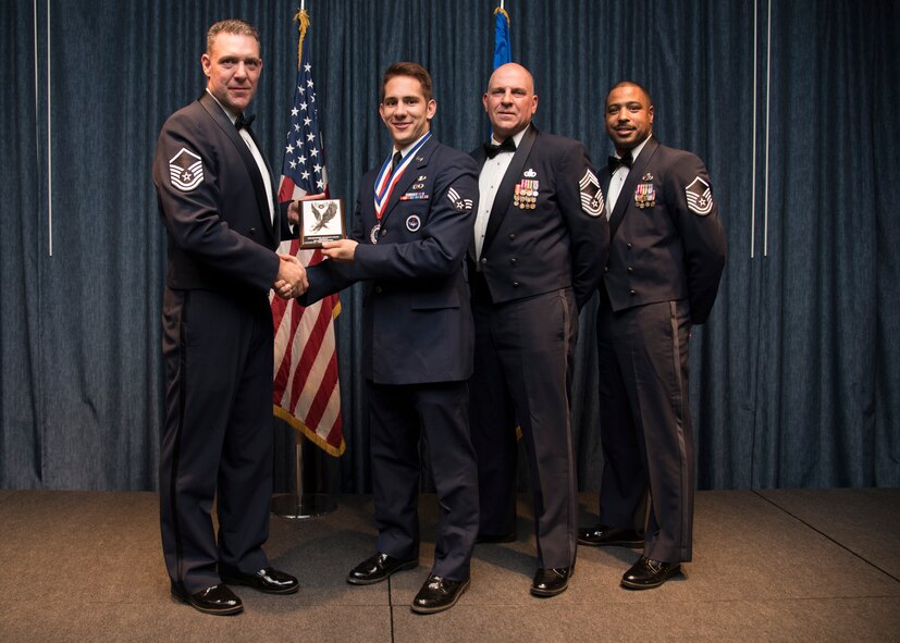 Senior Airman Adam Hertzberg from the 22nd Training Squadron, receives one of two distinguished graduate awards during the Airman Leadership School graduation Oct. 15, 2015, at Fairchild Air Force Base, Wash. The distinguished graduate is presented to the graduates in the top ten percent of the class based on the highest overall average in all graded areas. (U.S. Air Force photo/Airman 1st Class Sean Campbell)