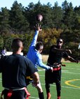 Nicolas Sisco, 90th Missile Maintenance Squadron Electrical Maintenance Team technician, runs past defensemen from Fort Carson, Colo., during a flag football game Oct. 17, 2015, at the U.S. Air Force Academy, Colo. The Warren team came in second in the tournament, falling to the undefeated team from Fort Carson, Colo. (U.S. Air Force photo by Senior Airman Brandon Valle)