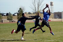 Tony Strickland, 4th Space Operations Squadron, makes a leaping catch between two 50th Security Forces Squadron defenders during the intramural flag football championship game at Schriever Air Force Base, Colorado, Thursday, Oct. 15, 2015. Strickland, who took the catch 42 yards for a touchdown, also returned an interception for a touchdown to lead 4 SOPS to a 25-0 victory. (U.S. Air Force photo/Christopher DeWitt) 