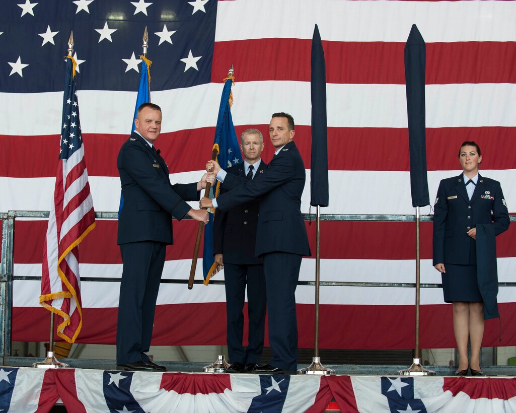 U. S. Air Force Col. Bruce Cox, 307th Bomb Wing commander, left, passes a guidon to Col. Denis Heinz, 489th Bomb Group commander, during the 489th BG Reactivation ceremony at Dyess Air Force Base, Texas,  Oct. 17, 2015. The unit will be furthering Total Force Integration, which aims to integrate active duty Air Force, Air Force Reserve, by using the B-1B Lancers at Dyess for their mission and the 7th Bomb Wing’s mission . (U.S. Air Force photo by Airman Quay Drawdy/Released)