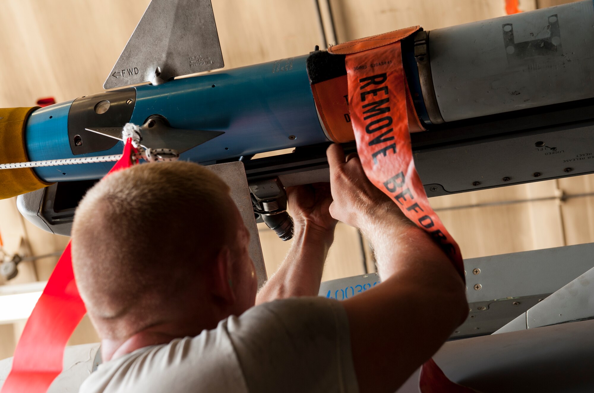U.S. Air Force Staff Sgt. Mike Goncalves, 44th Fighter Squadron weapons load crew chief, secures an AIM-9L/M Sidewinder missile during a weapons loading competition on Kadena Air Base, Japan, Oct. 19, 2015. These weapons loading competitions promote teamwork, readiness and warfighting integration ability. (U.S. Air Force photo by Airman Zackary A. Henry)