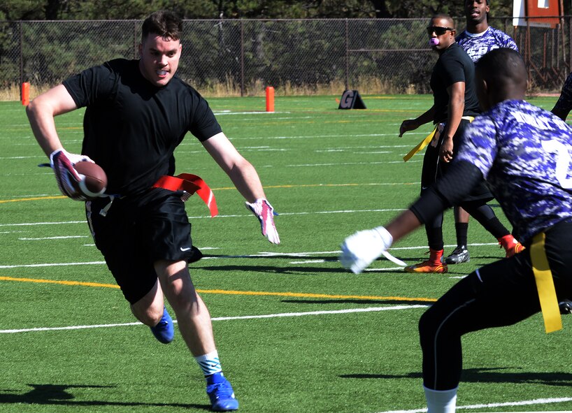 Kevin Tufts, 90th Missile Security Forces Squadron, attempts to avoid a defenseman from Fort Carson, Colo., during a flag football game Oct. 17, 2015, at the U.S. Air Force Academy, Colo. The Warren team played four games throughout the day, making it to the championship game where the faced Fort Carson for a second time. (U.S. Air Force photo by Senior Airman Brandon Valle)