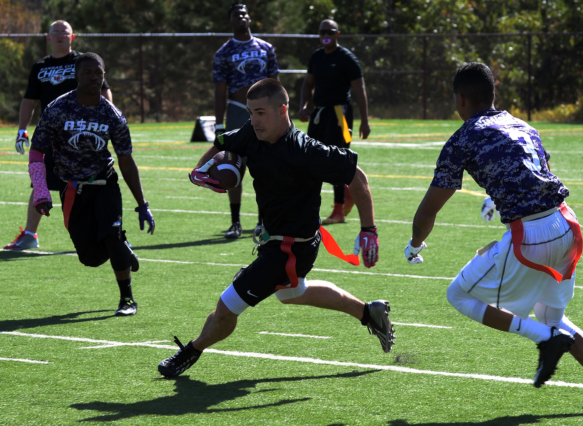 Nicolas Sisco, 90th Missile Maintenance Squadron Electrical Maintenance Team technician, runs past defensemen from Fort Carson, Colo., during a flag football game Oct. 17, 2015, at the U.S. Air Force Academy, Colo. The Warren team came in second in the tournament, falling to the undefeated team from Fort Carson, Colo. (U.S. Air Force photo by Senior Airman Brandon Valle)