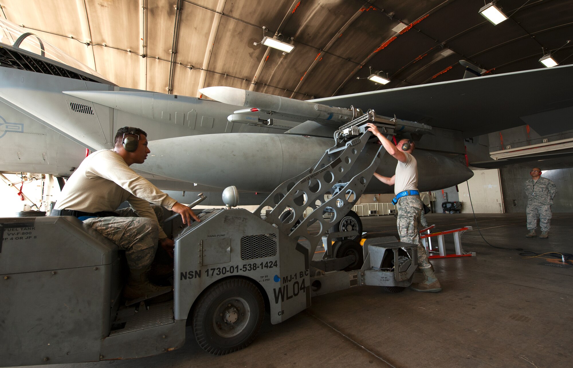 U.S. Air Force Staff Sgt. Mike Goncalves, 44th Fighter Squadron weapons load crew chief, secures a LAU-128 missile with Senior Airman Jacob Montiel, 44th FS weapons load crew member, during a weapons loading competition on Kadena Air Base, Japan, Oct. 19, 2015. The weapons load competition is a tradition held to raise morale, give airmen motivation to outperform their peers and set a higher standard for crews to come. (U.S. Air Force photo by Airman Zackary A. Henry)