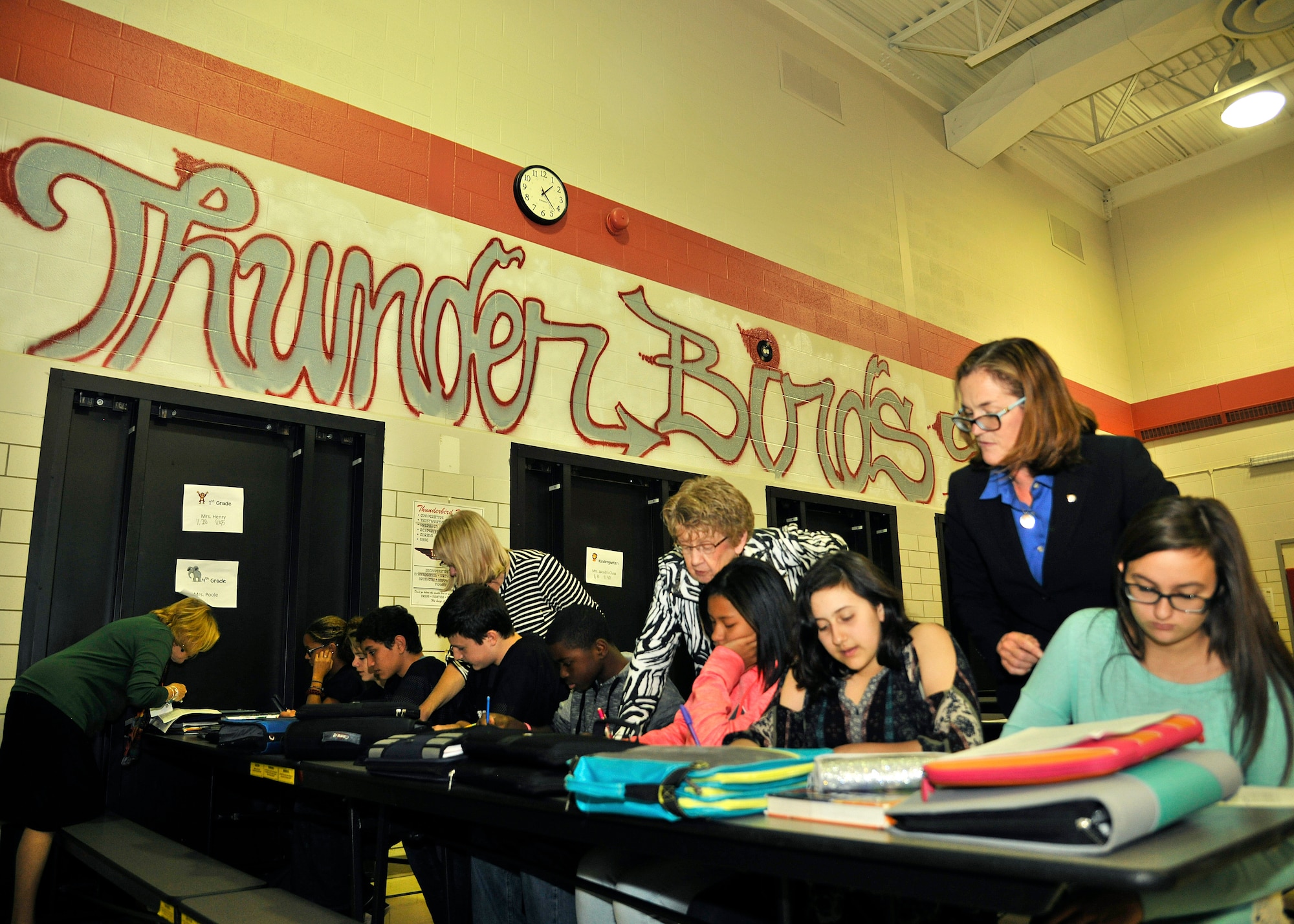 Teachers and representatives of Service Credit Union help out eighth grade students from Nathan Twining Elementary and Middle School research salary of the profession they had picked during the Credit Union 4 Reality event Oct. 15, 2015, on Grand Forks Air Force Base, North Dakota. Students were able to look over how much money their profession makes and calculate how much is deducted from taxes. (U.S. Air Force photo by Senior Airman Xavier Navarro/Released)