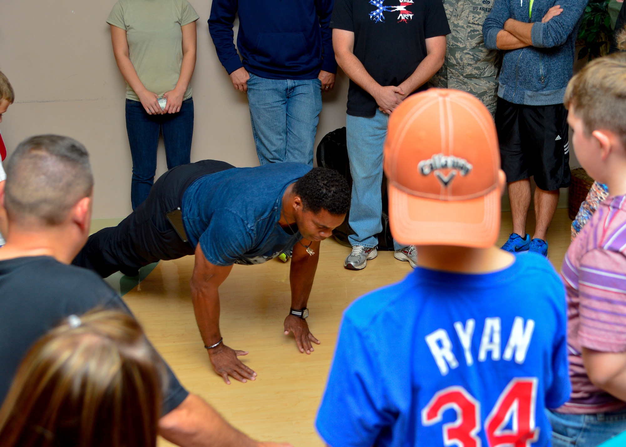 Herschel Walker performs push-ups for children Oct. 14, 2015, at the Youth Center on Dover Air Force Base, Del. Walker demonstrated how push-ups can be performed in a variety of ways to work different muscle groups and build strength in young athletes. (U.S. Air Force photo/Senior Airman William Johnson)