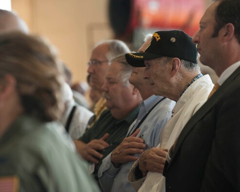 Former 489th Bombardment Group members place their hands over their hearts for the playing of the national anthem during the 489th Bomb Group reactivation ceremony at Dyess Air Force Base, Texas, Oct. 17, 2015. The 489th BG supported the landings in Normandy and flew missions into Germany, bombing strategic targets and participating in food drops for Allied Forces in France. (U.S. Air Force photo by Airman Quay Drawdy/Released)