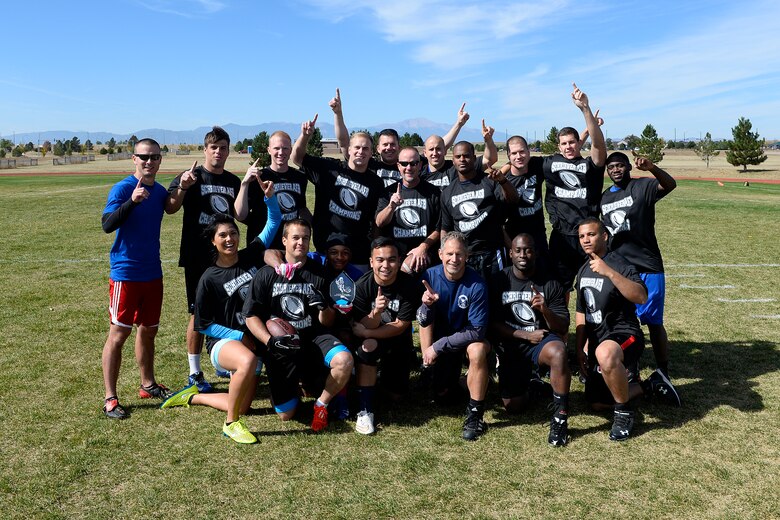 4th Space Operations Squadron team members celebrate with the intramural flag football championship trophy following their 25-0 defeat of 50th Security Forces Squadron in the championship game Thursday, Oct. 15, 2015, at Schriever Air Force Base, Colorado. 4 SOPS had three interceptions, one returned for a touchdown, to keep 50 SFS out of the end zone. (U.S. Air Force photo/Christopher DeWitt)