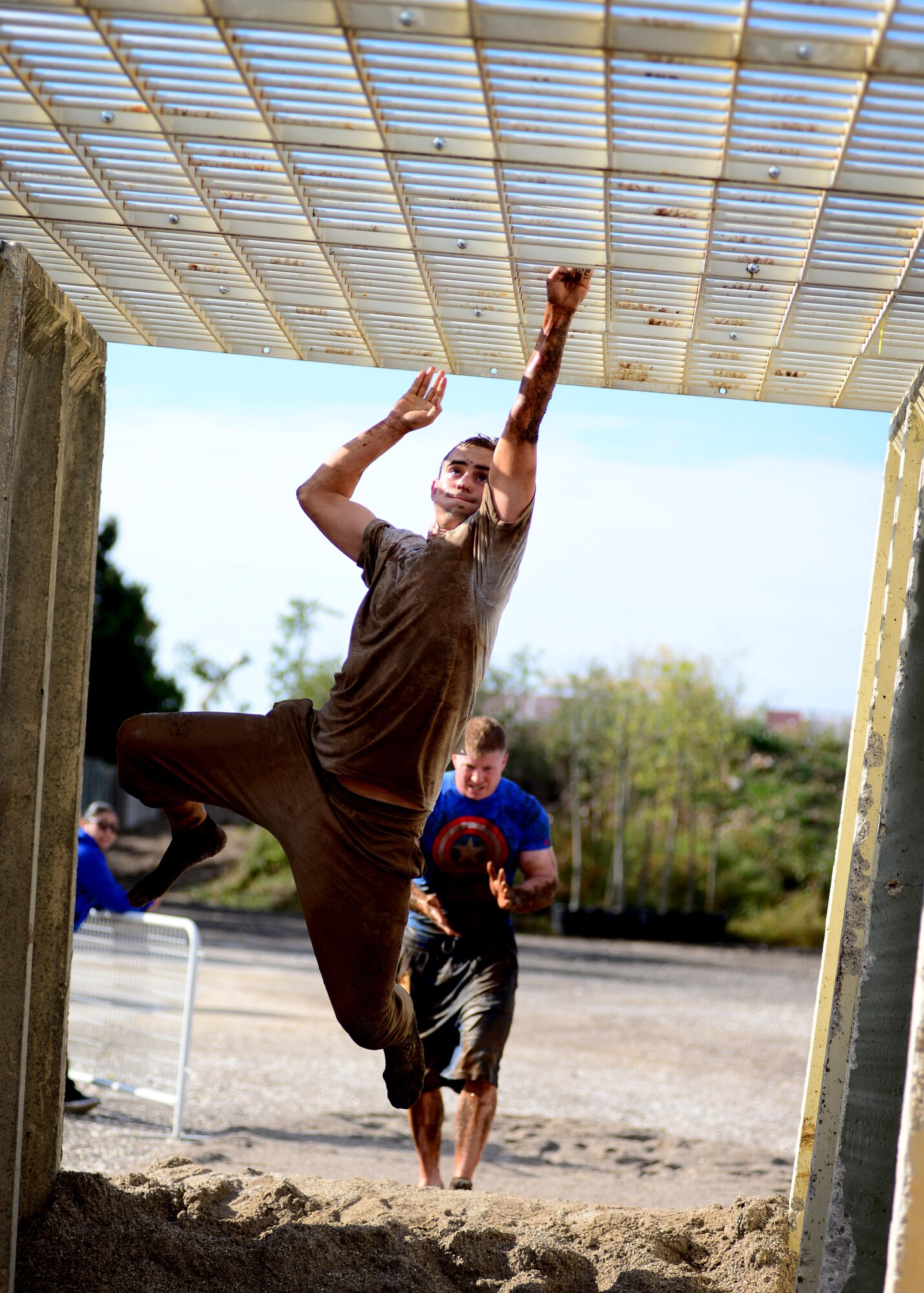 U.S. Air Force 1st Lt. Cole Johnson, 31st Logistics Readiness Squadron petroleum, oils and lubricants flight commander, climbs the monkey bars during the Wyvern Mud Run, Oct. 17, 2015, at Aviano Air Base, Italy. The six mile course included 400,000 pounds of mud with more than 12 obstacles, such as T-walls, low crawls and tire flips. (U.S. Air Force photo by Senior Airman Areca T. Bell/Released)