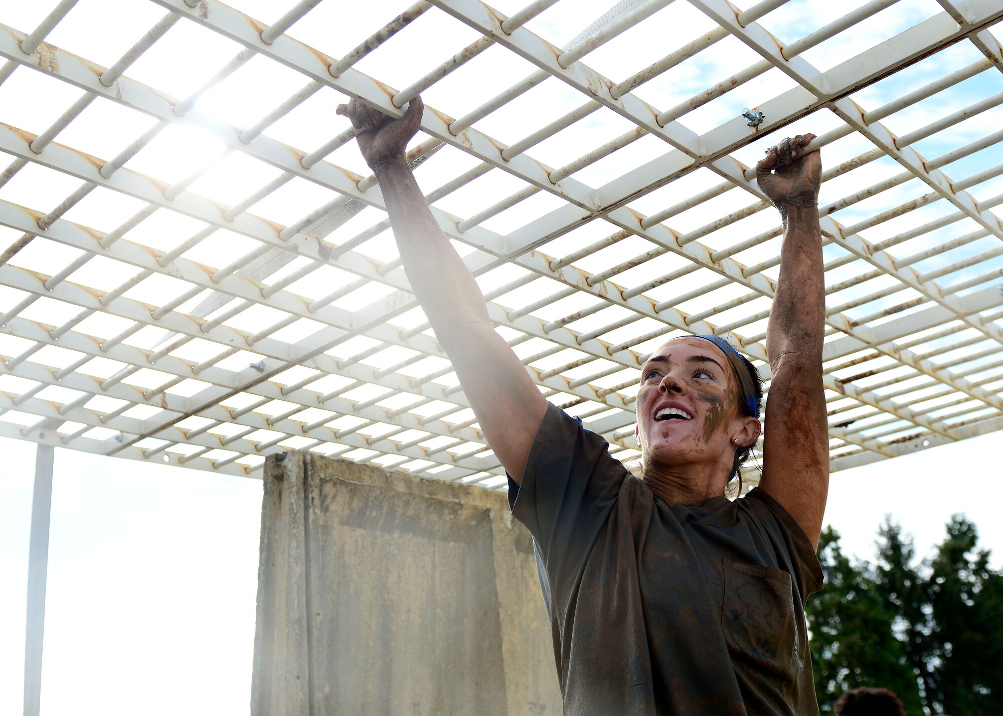 U.S. Air Force Senior Airman Chelsea Pires, 31st Dental Squadron technician, climbs the monkey bars during the Wyvern Mud Run, Oct. 17, 2015, at Aviano Air Base, Italy. The Wing Diversity Council and 31st Civil Engineer Squadron hosted the event, which awarded prizes to the top male and female, top team and top squadron team. (U.S. Air Force photo by Senior Airman Areca T. Bell/Released)