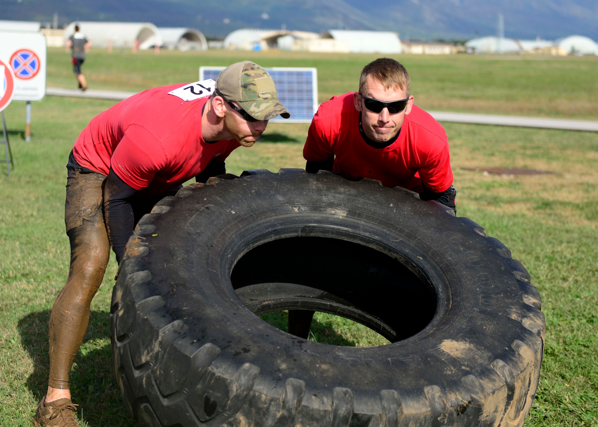U.S. Air Force Master Sgt. Michael Clark, 31st Munitions Squadron maintenance NCO in charge, and Tech. Sgt. Robert Pemberton, 31st MUNS maintenance floor chief, flip a tire during the Wyvern Mud Run, Oct. 17, 2015, at Aviano Air Base, Italy. The Wing Diversity Council and 31st Civil Engineer Squadron hosted the event, which awarded prizes to the top male and female, top team and top squadron team. (U.S. Air Force photo by Senior Airman Areca T. Bell/Released)