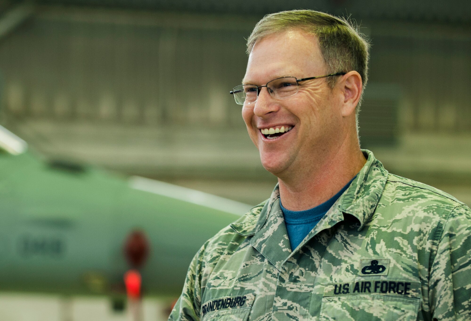 U.S. Air Force Chief Master Sgt. Craig Brandenburg, 52nd Maintenance Group wing weapons manager, watches competing teams during the quarterly weapons load competition in Hangar 1 on Spangdahlem Air Base, Germany, Oct. 16, 2015. The competition tested the accuracy and speed of the maintenance Airmen’s loading capabilities. Members of the winning team will move onto the annual weapons load competition, where they will compete with three other quarterly competition winning teams. (U.S. Air Force photo by Airman 1st Class Timothy Kim/Released)