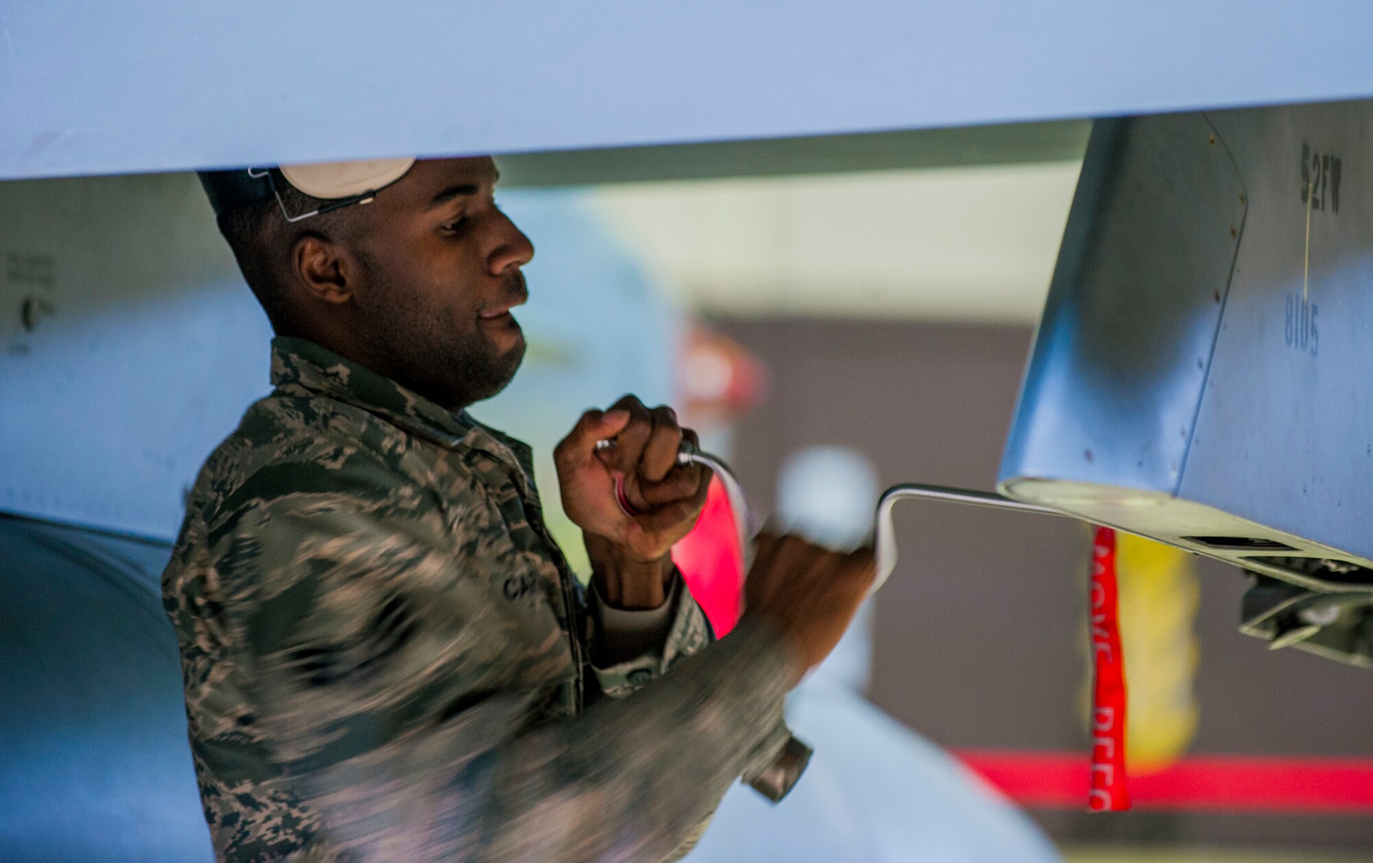 U.S. Air Force Senior Airman Tyrail Carter, a 52nd Aircraft Maintenance Squadron weapons systems specialist and competition team member, works on an F-16 Fighting Falcon fighter aircraft’s wing during the quarterly weapons load competition in Hangar 1 on Spangdahlem Air Base, Germany, Oct. 16, 2015. The competition required two teams of three competing members to load weapons to the wings of an F-16 as quickly and accurately as possible. (U.S. Air Force photo by Airman 1st Class Timothy Kim/Released)