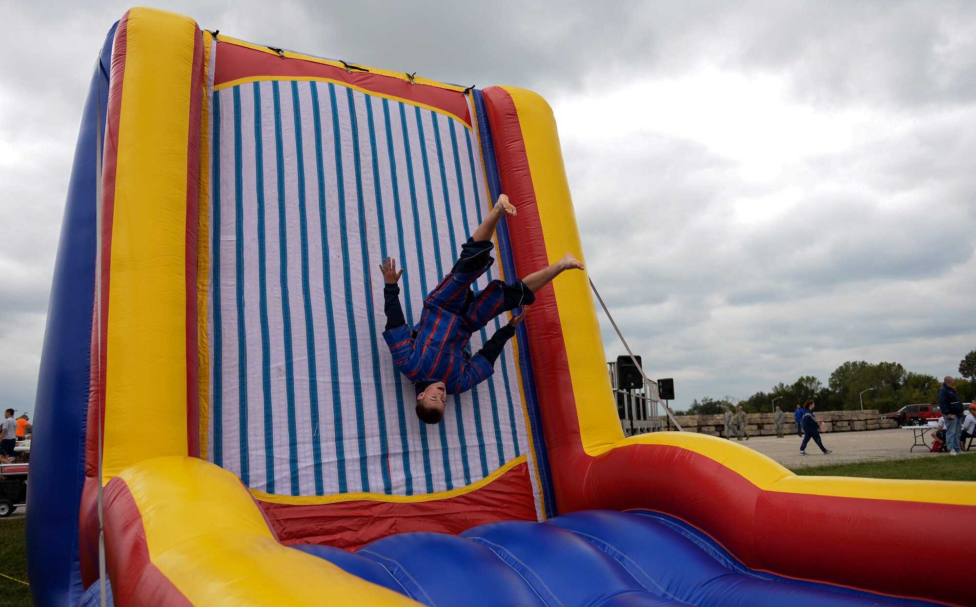 U.S. Air Force Airman 1st Class Austin Moriarty, 509th Munitions Squadron weapons maintenance team member, performs a flip on the velcro wall fling during Wingman Day, Oct. 9, 2015, at Whiteman Air Force Base, Mo. Events were held throughout the day to inform and educate Airmen about available resources and the importance of resiliency. (U.S. Air Force photo by Senior Airman Sandra Marrero/Released)