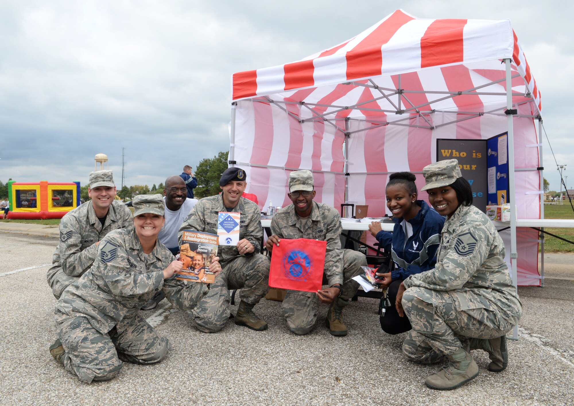 Whiteman Warriors pose in front of the Airman and Family Readiness Center (A&FRC) booth during Wingman Day, Oct. 9, 2015 at Whiteman Air Force Base, Mo. The A&FRC is just one resource available to Airmen that provides information, education, training and support programs to enhance resiliency. (U.S. Air Force photo by Tech. Sgt. Miguel Lara III/Released)