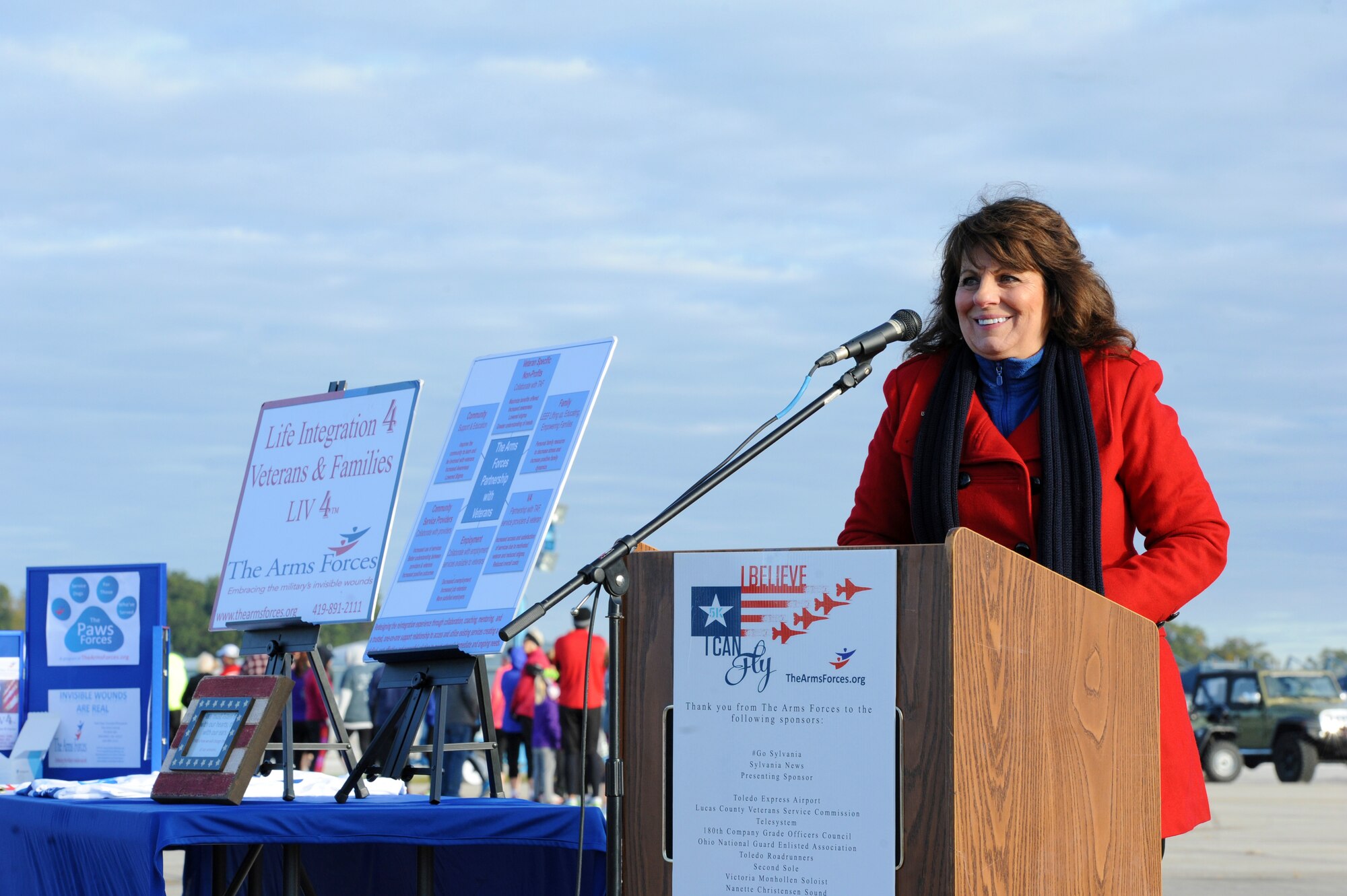 Pam Hayes, founder of The Arms Forces and coordinator of the I Believe I Can Fly 5k, addresses runners and supporters before the race Oct. 18, 2015 in Swanton, Ohio. Men and Women of the 180th FW traded combat boots for running shoes, joining local community members in a 5k race, hosted by the Arms Forces Organization, raising awareness about traumatic brain injuries. The Arms Forces provides education and programs allowing veterans past and present, who have a traumatic brain injury or post-traumatic stress disorder to find understanding, purpose and direction as they face the other war while living at home with their invisible injury. Air National Guard Photo by Staff Sgt. John Wilkes/Released.