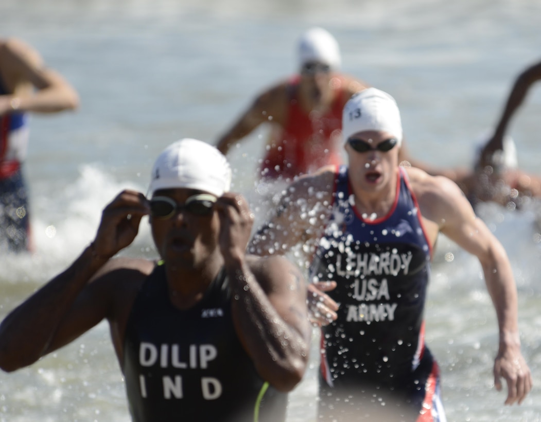 Army 1st Lt. Gene LeHardy (right) runs out of the surf during the 1.5-kilometer swim leg of the men's triathlon in downtown Pohang, South Korea, during the CISM World Games Oct. 10, 2015.