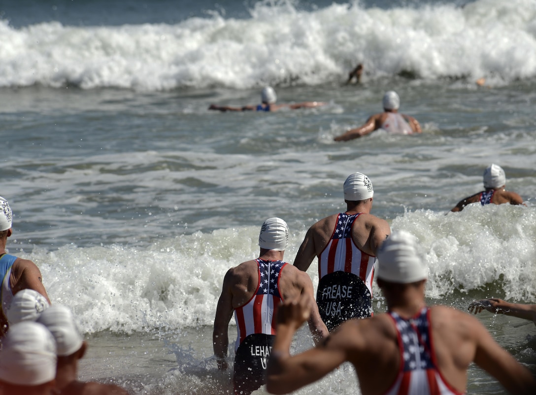 USA team members enter the surf for their second lap of the 1.5-kilometer swim during the men's triathlon in Pohang, South Korea, Oct. 10, 2015, during the CISM World Games.