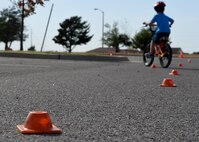 ALTUS AIR FORCE BASE, Okla. – A child rides a bike through an obstacle course during a children’s bicycle safety event at the Balfour Beatty Community Center, Oct. 17, 2015. The 97th Air Mobility Wing Safety Office hosted the event along with emergency responders to educate children on bicycle safety such as wearing proper safety gear and inspecting their bike’s for any faults. (U.S. Air Force photo by Senior Airman Franklin R. Ramos/Released)
