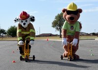 ALTUS AIR FORCE BASE, Okla. – Sparky the fire dog and Earl the safety squirrel, prepare to race during a children’s bicycle safety event at the Balfour Beatty Community Center, Oct. 17, 2015. The 97th Air Mobility Wing Safety Office hosted the event along with emergency responders to educate children on bicycle safety. (U.S. Air Force photo by Senior Airman Franklin R. Ramos/Released)