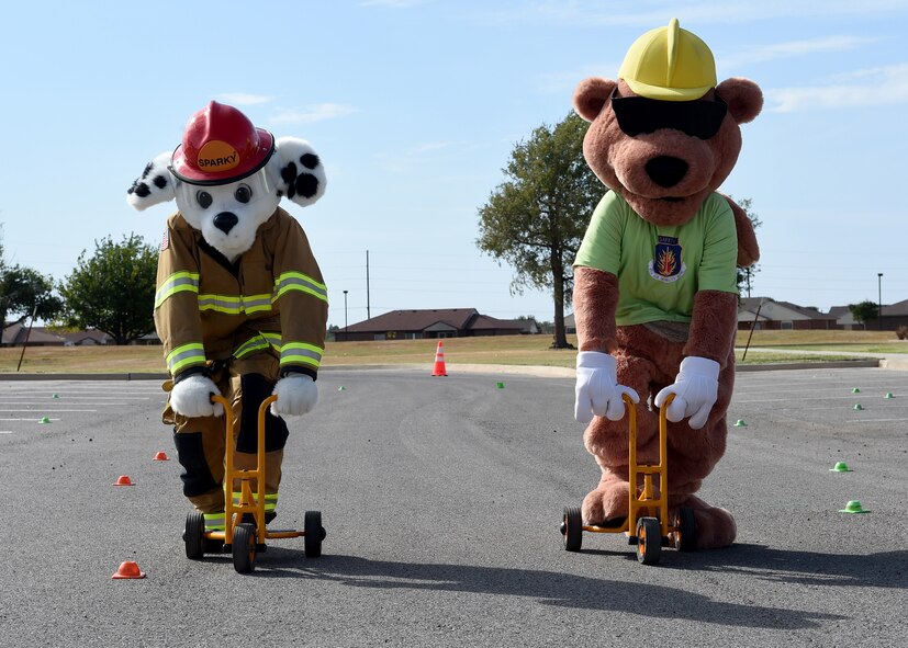 ALTUS AIR FORCE BASE, Okla. – Sparky the fire dog and Earl the safety squirrel, prepare to race during a children’s bicycle safety event at the Balfour Beatty Community Center, Oct. 17, 2015. The 97th Air Mobility Wing Safety Office hosted the event along with emergency responders to educate children on bicycle safety. (U.S. Air Force photo by Senior Airman Franklin R. Ramos/Released)