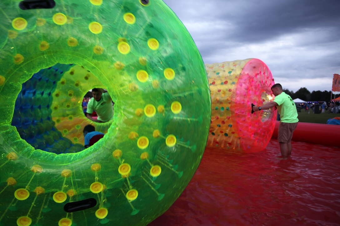 Pfc. Anthony Jerome-Malfo, left, and Lance Cpl. Dean Desana spin large inflatable tubes for children during the 34th annual Havelock Chili Festival hosted by the Havelock Chamber of Commerce at the Walter B. Jones Park in Havelock, N.C., Oct. 16, 2015. Volunteers with the Single Marine Program came together to help set up the booths that housed the chili and chicken vendors, supervise the children’s bouncy house activities and make the park spotless again after the festival was over. Along with the assistance of Marine volunteers and other volunteers, the chamber raises funds for local charities and sees who has the best chili and Buffalo wings. The winner goes on to compete in the International World Chili Championship. Both Jerome-Malfo and Desana are students at the Center for Naval Aviation Technical Training. (U.S. Marine Corps photo by Lance Cpl. Jason Jimenez/Released)