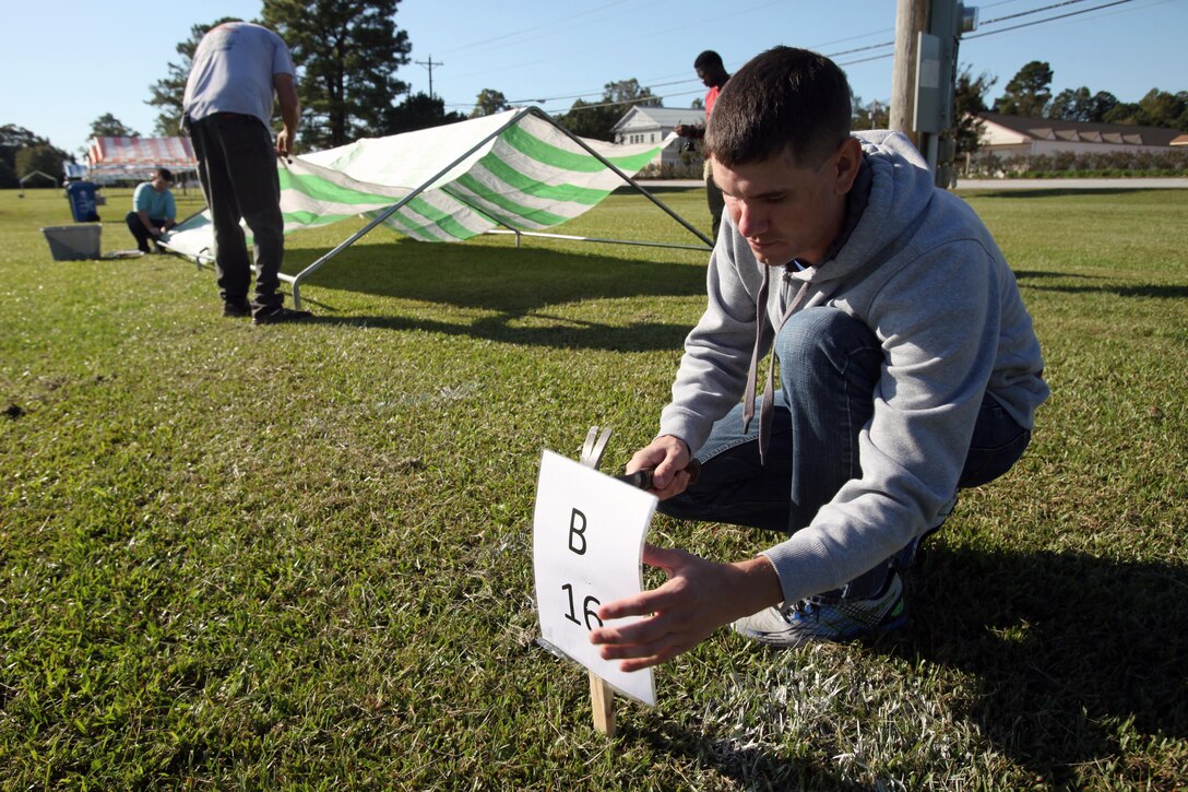 Sgt. Brendan Cregg hammers in a numbered post to indicate a particular vendor spot during the 34th annual Havelock Chili Festival hosted by the Havelock Chamber of Commerce at the Walter B. Jones Park in Havelock, N.C., Oct. 16, 2015. Volunteers with the Single Marine Program came together to help set up the booths that housed the chili and chicken vendors, supervise the children’s bouncy house activities and make the park spotless again after the festival was over. Along with the assistance of Marine volunteers and other volunteers, the chamber raises funds for local charities and sees who has the best chili and Buffalo wings. The winner goes on to compete in the International World Chili Championship. Cregg is a percussionist with the 2nd Marine Aircraft Wing Band. (U.S. Marine Corps photo by Lance Cpl. Jason Jimenez/Released)