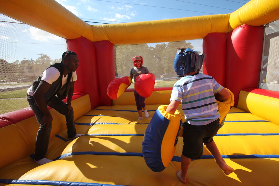 Lance Cpl. Tayeb Ihekoronye, left, supervises a big glove bout for 9-year-old Rilie, center, and 7-year-old Carson, during the 34th annual Havelock Chili Festival hosted by the Havelock Chamber of Commerce at the Walter B. Jones Park in Havelock, N.C., Oct. 16, 2015. Volunteers with the Single Marine Program came together to help set up the booths that housed the chili and chicken vendors, supervise the children’s bouncy house activities and make the park spotless again after the festival was over. Along with the assistance of Marine volunteers and other volunteers, the chamber raises funds for local charities and sees who has the best chili and Buffalo wings. The winner goes on to compete in the International World Chili Championship. Ihekoronye is a student at the Center for Naval Aviation Technical Training. (U.S. Marine Corps photo by Lance Cpl. Jason Jimenez/Released)
