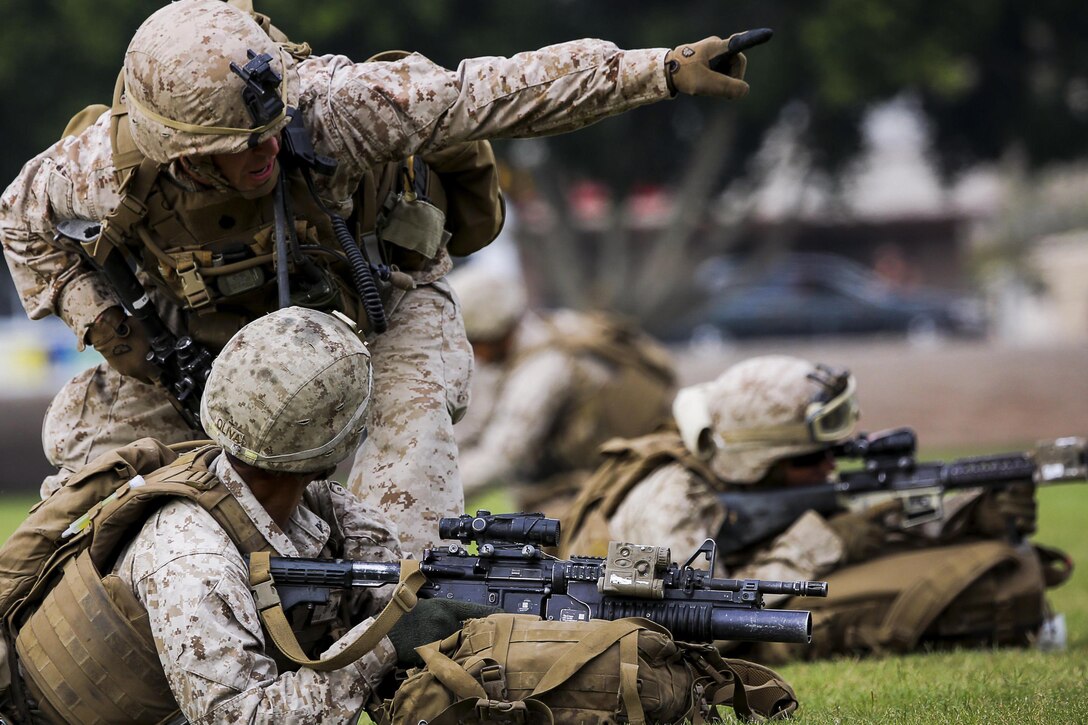 A Marine Corps squad leader directs Marines to their objective point during a noncombatant evacuation exercise as part of the Weapons and Tactics Instructor Course 1-16 at Kiwanis Park in Yuma, Ariz., Friday, Oct. 16, 2015. The Marines are with the 2nd Battalion, 7th Marine Regiment. Marine Corps photo by Cpl. Travis Gershaneck