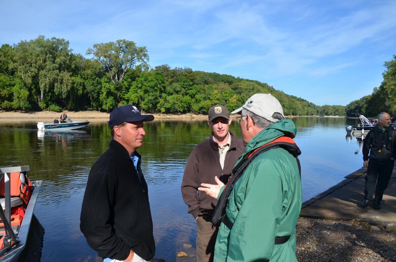 Dan Kelner, left, district mussel biologist, and Nathan Eckert, U.S. Fish and Wildlife Service mussel biologist, talk with Secretary of the U.S. Department of the Interior Ken Salazar during an endangered mussel release in the Mississippi River Aug. 17, 2012.