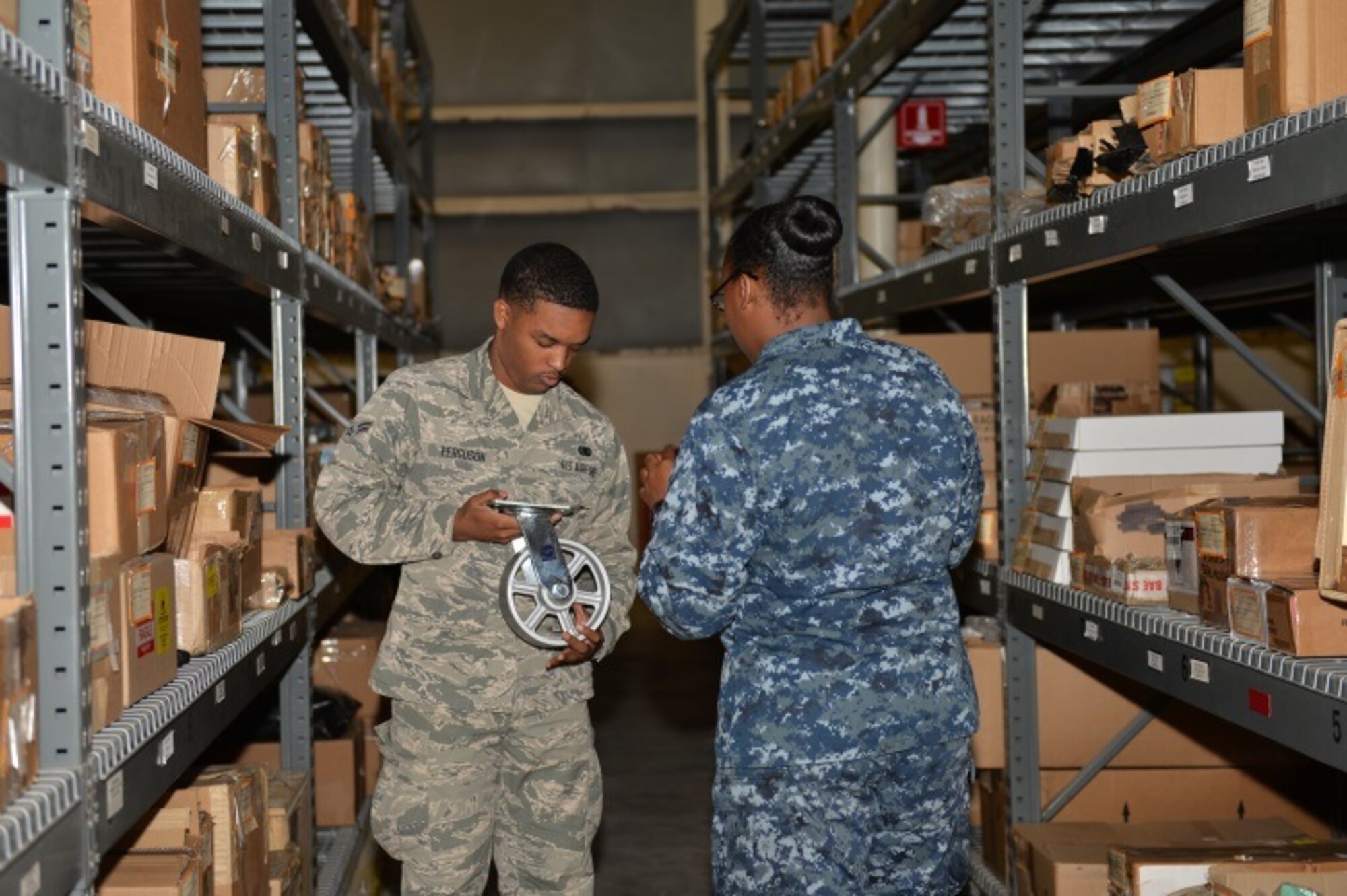 Airman 1st Class Kristoffer Ferguson, 96th Logistics Readiness Squadron F-35 supply apprentice, and Petty Officer 2nd Class Whitney Moss, 33rd Maintenance Squadron logistics specialist, verify equipment barcodes at Eglin Air Force Base, Fla., Oct. 15, 2015. The 96th LRS supplies the F-35 Lightning II A and C parts and equipment to the 33rd Fighter Wing and Navy Strike Fighter Squadron 101 Grim Reapers. (U.S. Air Force Photo/Senior Airman Andrea Posey)