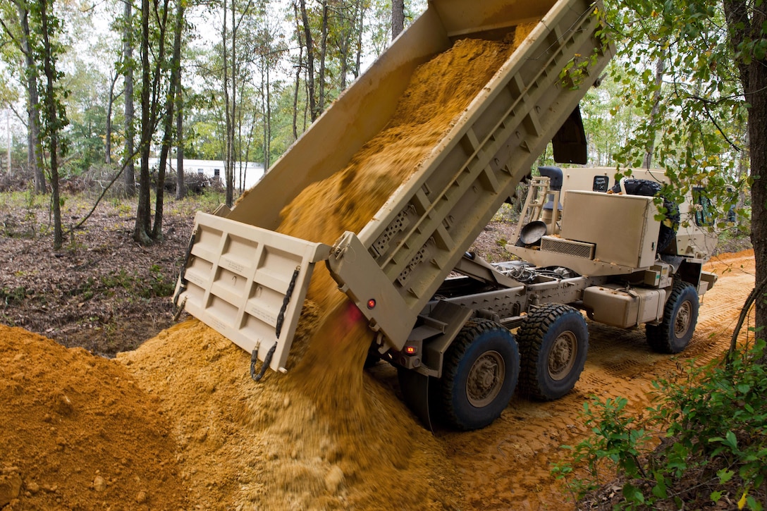 A South Carolina Army National Guardsman dumps a truck load of clay dirt to rebuild a road that was washed out in Swansea, S.C., Oct. 13, 2015, after historic statewide flooding in early October. South Carolina Air National Guard photo by Tech. Sgt. Jorge Intriago