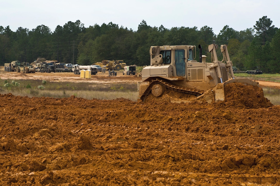 A South Carolina Army National Guardsman operates a bull dozer to level out clay dirt in Swansea, S.C., Oct. 13, 2015, to rebuild a nearby road after historic statewide flooding in early October. South Carolina Air National Guard photo by Tech. Sgt. Jorge Intriago