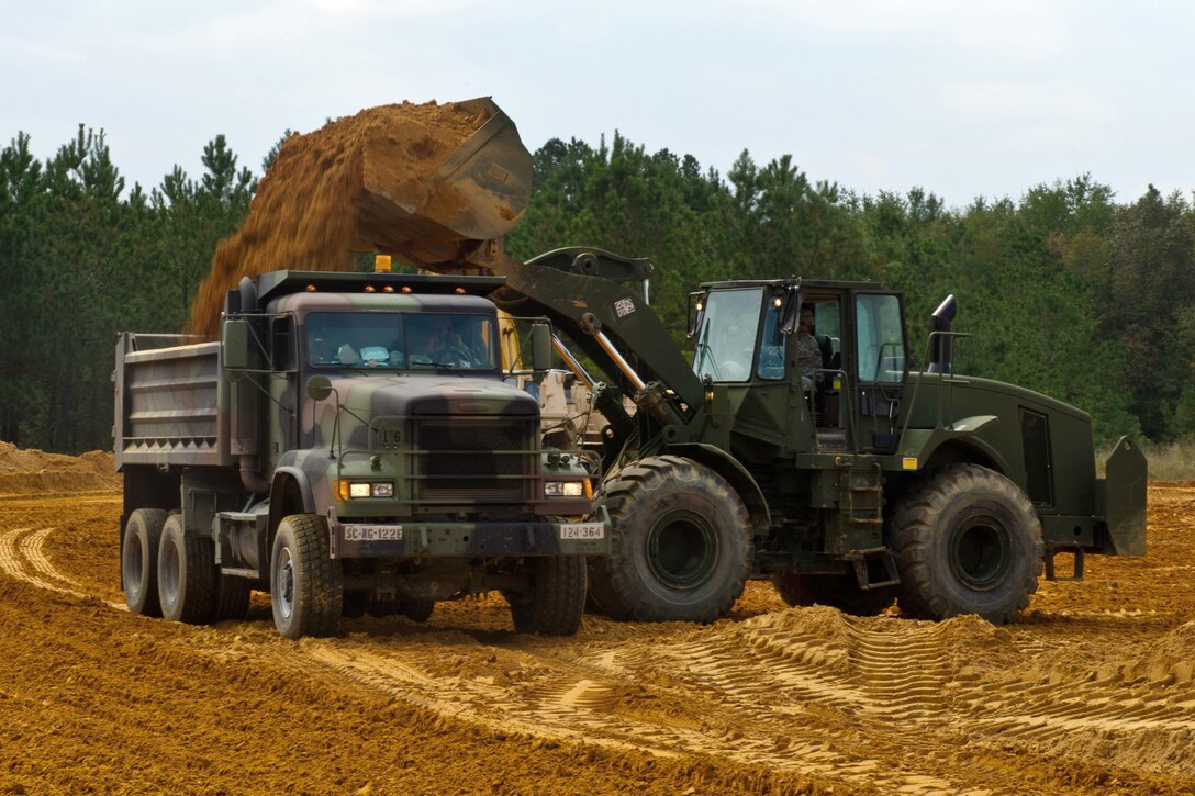A South Carolina Army National Guardsman uses a front loader to fill a dump truck full of clay dirt in Swansea, S.C., Oct. 13, 2015, to rebuild a nearby road after historic statewide flooding in early October. South Carolina Air National Guard photo by Tech. Sgt. Jorge Intriago