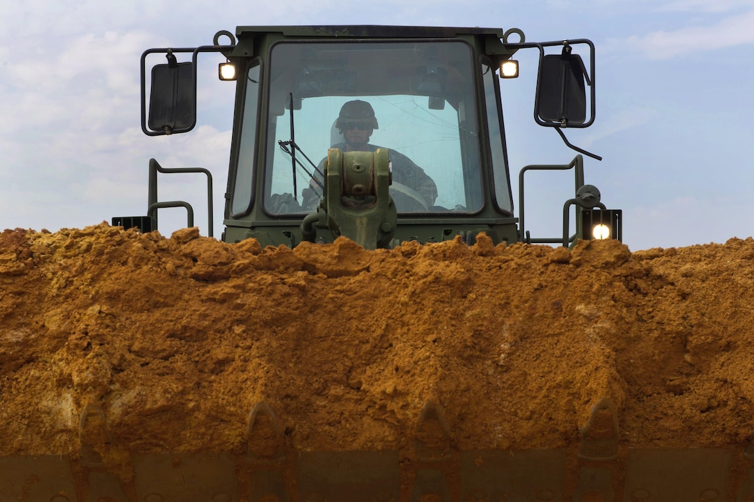 South Carolina Army National Guard Sgt. Jeffery Bucknam operates a front loader during road rebuilding operations in Swansea, S.C., Oct. 13, 2015, after historic statewide flooding in early October. Bucknam is a heavy equipment operator assigned to the 124th Engineer Company. South Carolina Air National Guard photo by Tech. Sgt. Jorge Intriago