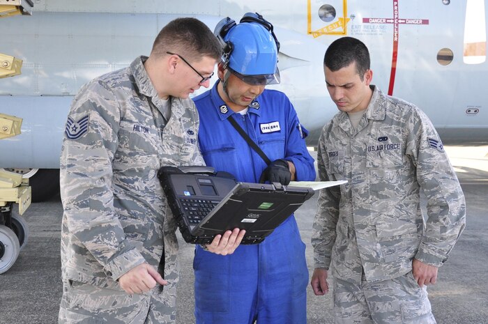 A Japan Maritime Self-Defense Force member works with Yokota technicians at Naval Air Facility Atsugi, Japan, Oct. 8, 2015. The Yokota technicians provided specialized maintenance test equipment and on-the-job training to the JMSDF maintenance personnel. 
