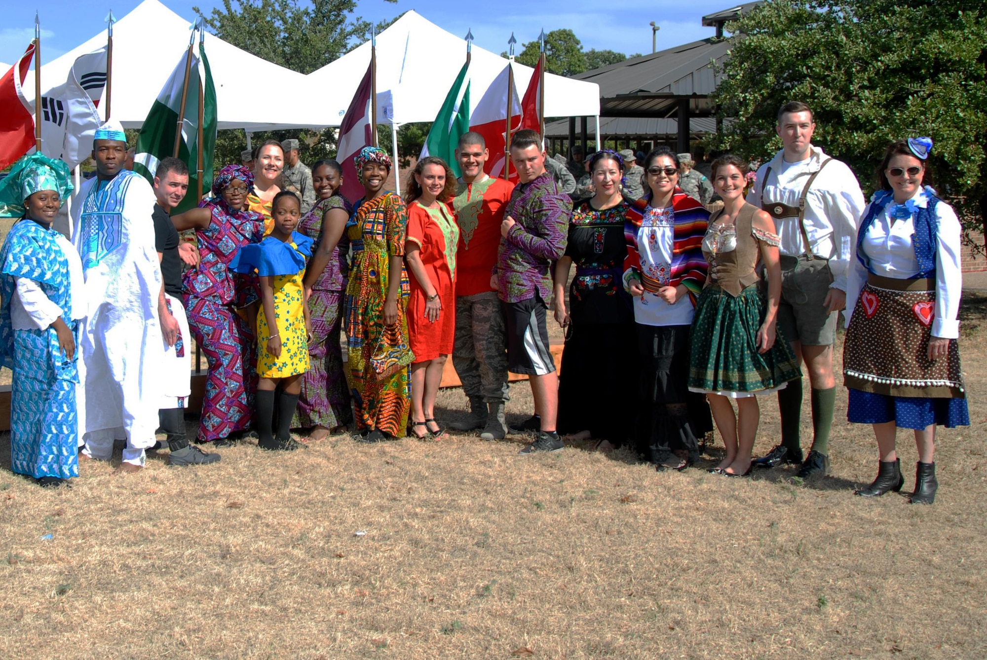 Volunteers pose for a photo during Multicultural Day outside the Western Winds Dining Facility on Goodfellow Air Force Base, Texas, Oct. 19, 2015. The volunteers for the event consisted of civilians, active duty service members and even International Military Officers. (U.S. Air Force photo by Senior Airman Joshua Edwards/Released)