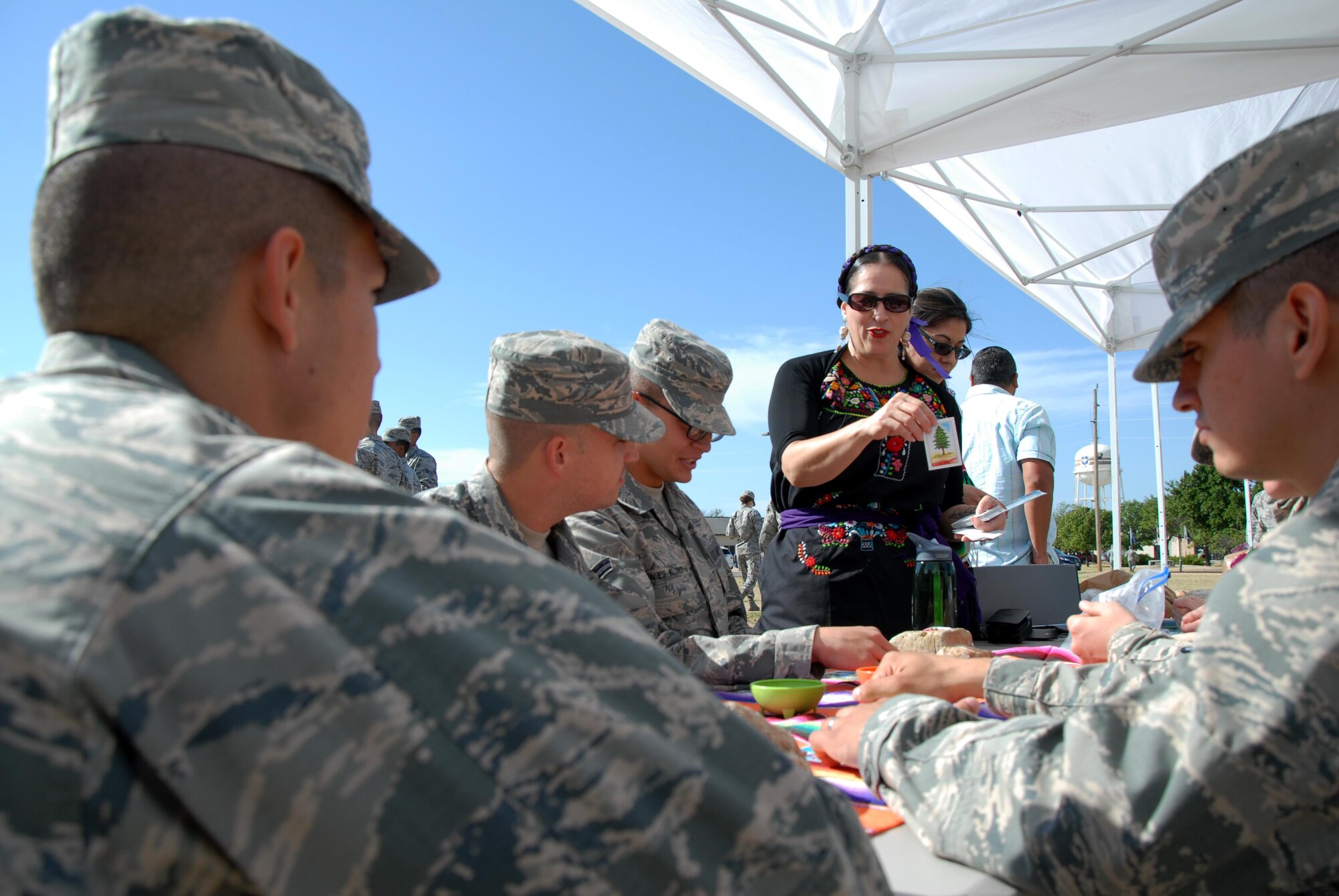 Cecilia Diaz, 17th Medical Operations Squadron Family Advocacy Program manager, announces the word tree in Spanish during a game of picture bingo during Multicultural Day at the Western Winds Dining Facility on Goodfellow Air Force Base, Texas, Oct. 19, 2015. During Multicultural Day, individuals could sample food from different countries and participate in a fashion show, where they would get to try on clothes from around the world. (U.S. Air Force photo by Senior Airman Joshua Edwards/Released)