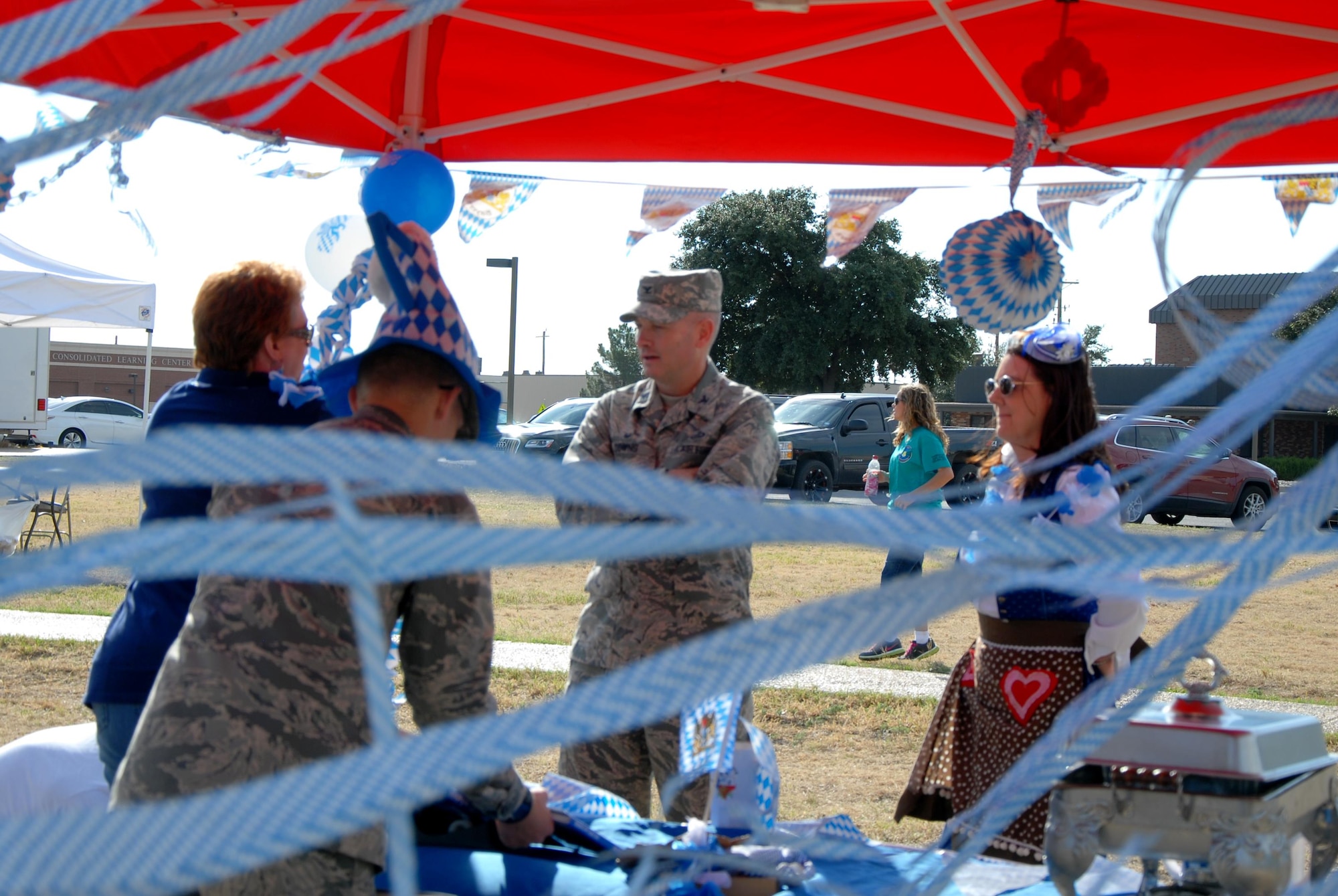 U.S. Air Force Col. Michael L. Downs, 17th Training Wing Commander, speaks with volunteers at the German booth during Multicultural Day outside the Western Winds Dining Facility on Goodfellow Air Force Base, Texas, Oct. 19, 2015. The German booth, as well as several other booths, provided displays and food samplings. (U.S. Air Force photo by Senior Airman Joshua Edwards/Released)