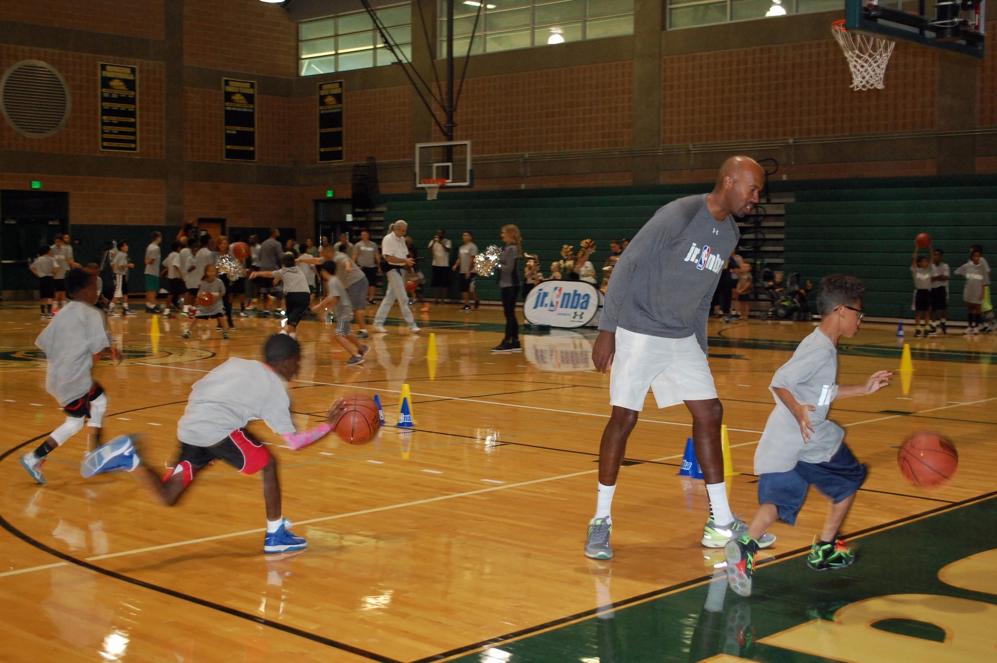 NBA Legend and ESPN analyst Bruce Bowen encourages Jr. NBA clinic participants during a dribbling drill. Bowen shared his enthusiasm for the sport, physical fitness and healthful living with the participants and their family members. (U.S. Air Force photo/Carole Chiles Fuller/Released)