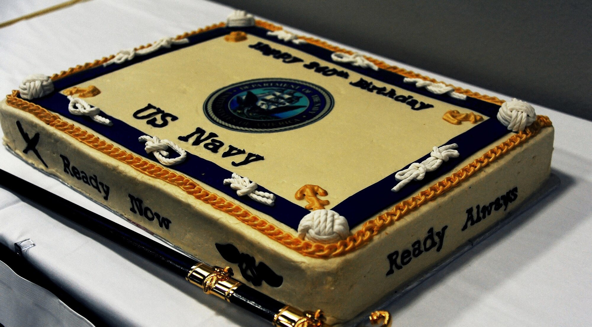 A displayed cake represents the celebration of the Navy’s 240th birthday during the Navy Day Ball at the Event Center on Goodfellow Air Force Base, Oct. 9, 2015. A saber is used to cut the cake during the cake cutting ceremony. (U.S. Air Force photo by Airman Caelynn Ferguson/Released)