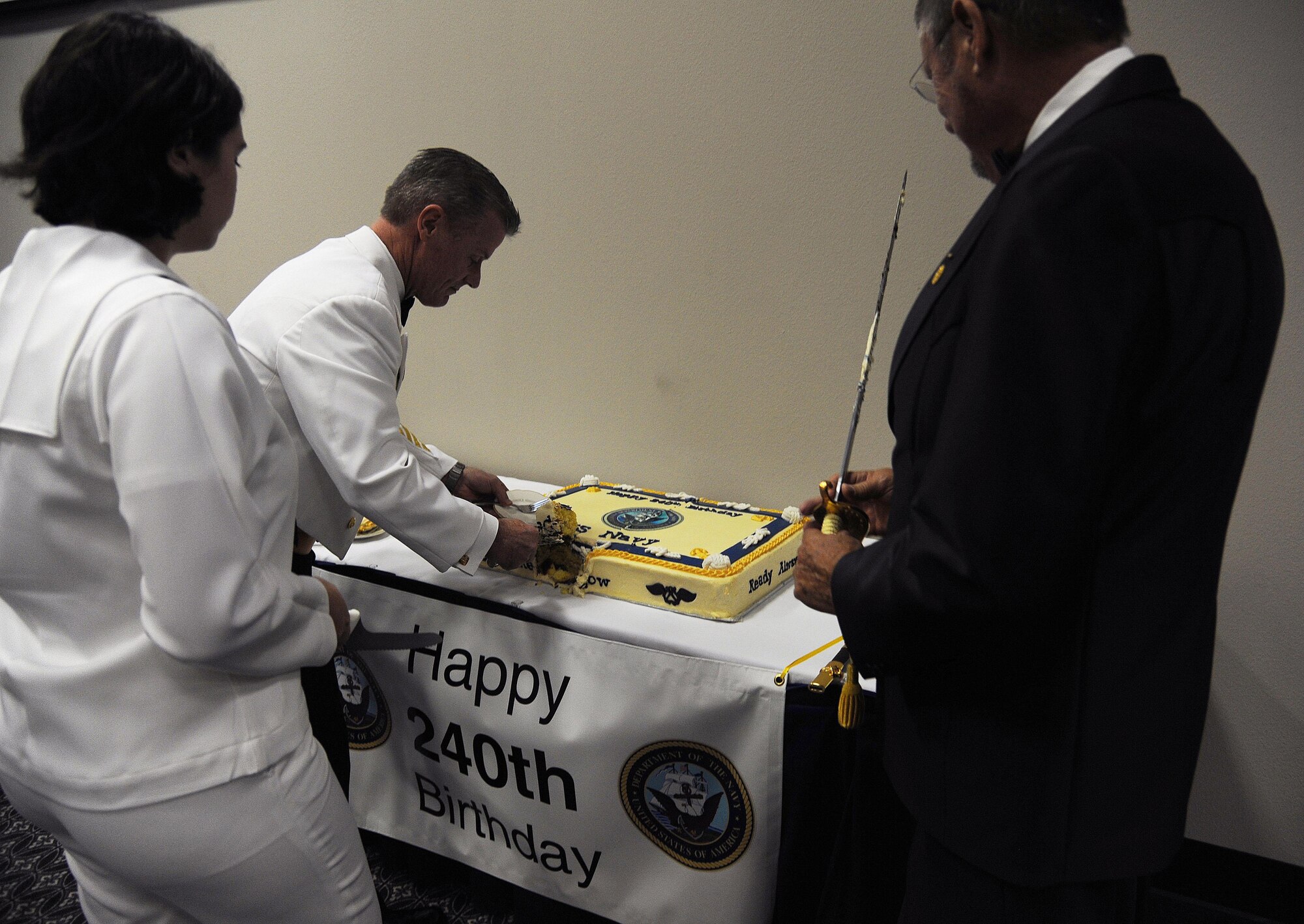 U.S. Navy Command Master Chief Christopher Angstead, Command Master Chief for Navy Medicine Education and Training Command Headquarters, passes out cake after the cake cutting ceremony during the Navy Day Ball at the Event Center on Goodfellow Air Force Base, Oct. 9, 2015. The first two pieces were given to retired Command Master Chief Petty Officer Jerry Marlett, the oldest Sailor, and Seaman Apprentice Bethany Dodson, the youngest sailor. (U.S. Air Force photo by Airman Caelynn Ferguson/Released)

