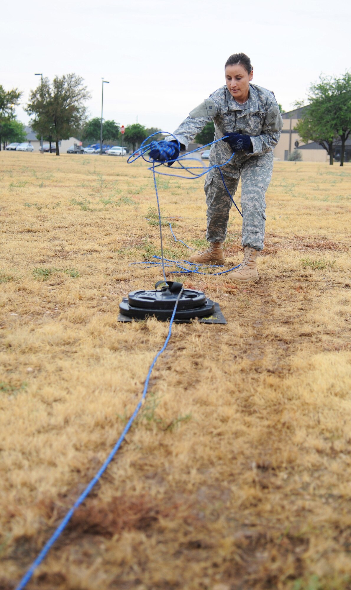 U.S. Army Master Sgt. Adriana A. Vargas, 344th Military Intelligence Battalion first sergeant, wraps a rope around her hands to pull a weight on the rope pull obstacle during the Annual Fire Muster Challenge beside the Fire Department at Goodfellow Air Force Base, Oct. 9, 2015. Participants had to stay stationary and pull the weight hand over hand to pass on to the next obstacle in the challenge. (U.S. Air Force photo by Airman Caelynn Ferguson/Released)