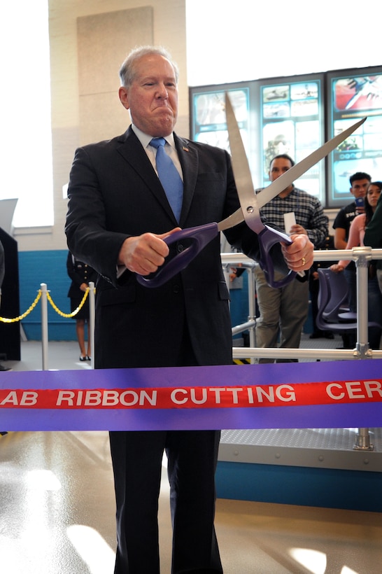 Frank Kendall, undersecretary of defense for acquisition, technology and logistics, prepares to cut the ceremonial ribbon during a ceremony at the Flexible Aviation Classroom Experience lab at Francis L. Cardozo Education Campus in Washington, D.C. Oct. 20, 2015. DoD photo by Marvin Lynchard