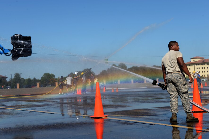 Airmen Johnathan McKay, 42nd Civil Engineer Squadron Civil Engineer Flight fire fighter, holds onto a water hose during the 2015 Maxwell Fire Muster Oct. 16, 2015, at Maxwell Air Force Base, Ala. The Fire Muster is a competition consisting of six fire services themed obstacles and challenges between different units.  (U.S. Air Force photo by Airman 1st Class Alexa Culbert)