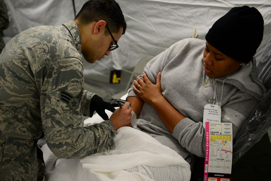 U.S. Air Force Senior Airman Alex Garcia-Fantauzzi, 633rd Inpatient Operations Squadron aerospace medical technician, writes a time stamp for patient reception during a mass casualty exercise at Langley Air Force Base, Va., Oct. 15, 2015. The exercise was aimed to teach and increase Airmen’s capabilities for a real-world deployments. (U.S. Air Force photo by Staff Sgt. Ciara Gosier/Released)